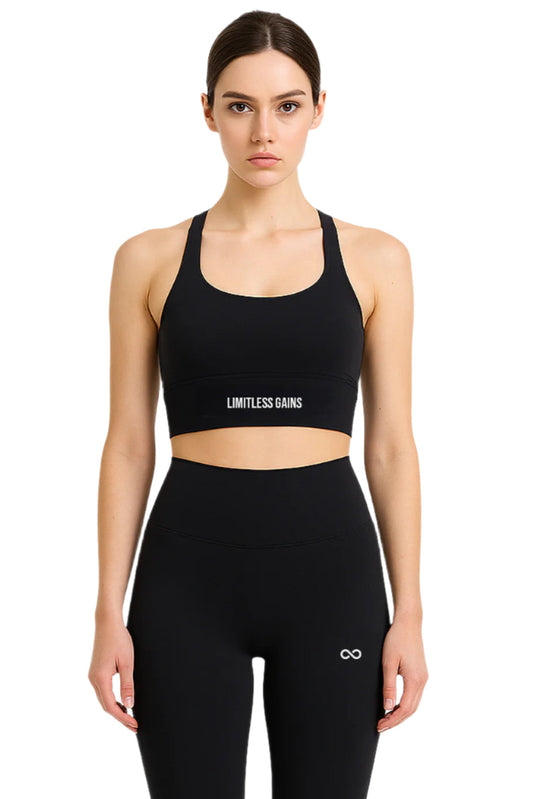 Woman wearing a black sports bra and leggings with 'Limitless Gains' branding on a white background