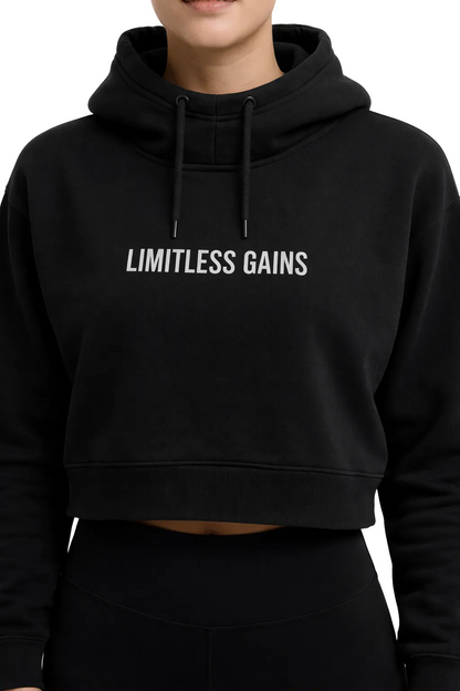 Black hoodie with 'LIMITLESS GAINS' text worn by a person on a white background