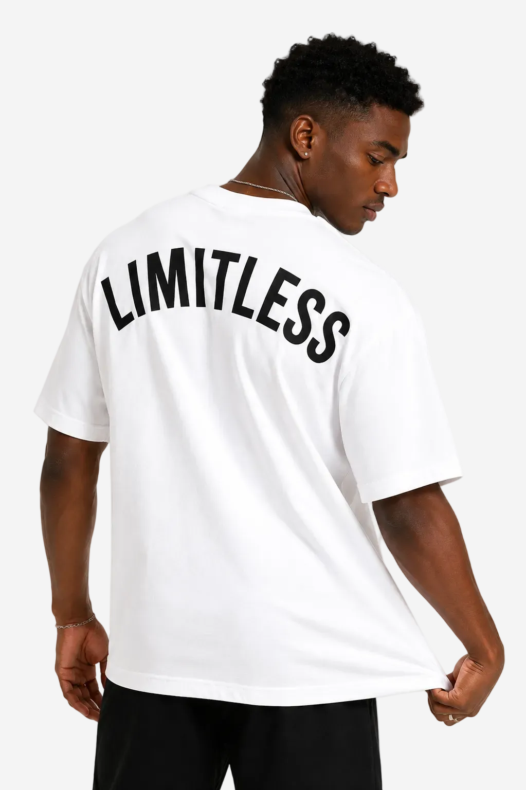 A man wearing a white short-sleeve t-shirt with the word 'LIMITLESS' printed in black arched text across the back, shown from behind against a plain white background.