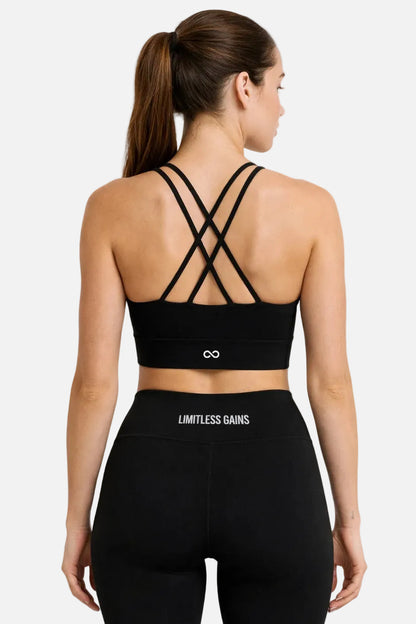 Woman wearing a black sports bra and leggings with 'Limitless Gains' branding on a white background