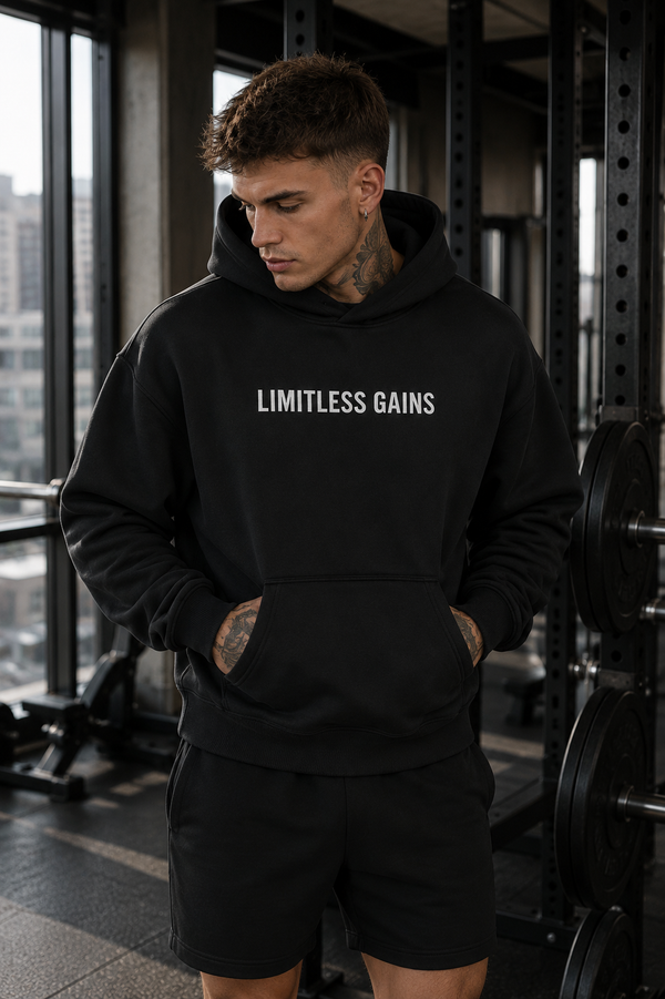 Person wearing a black hoodie with 'Limitless Gains' text in a gym setting