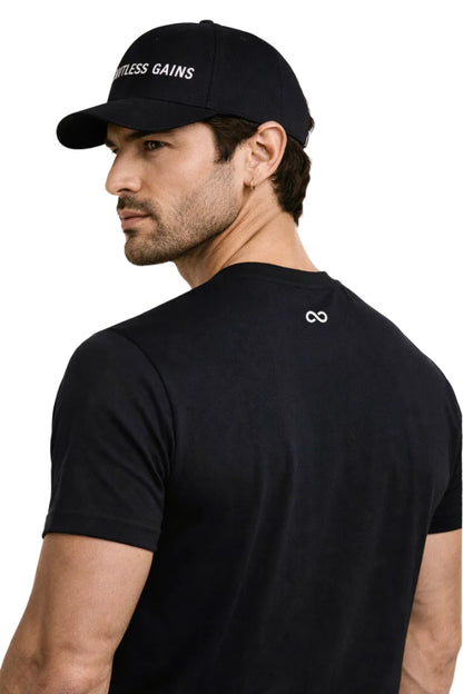 Man wearing a black cap and t-shirt with visible LIMITLESS GAINS branding on a white background