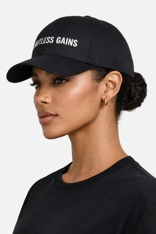 Woman wearing a black cap with 'Limitless Gains' text on a white background