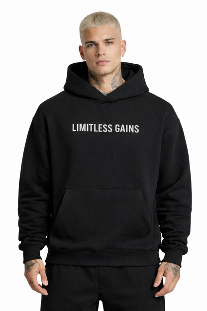 Person wearing a black hoodie with 'LIMITLESS GAINS' text on a white background
