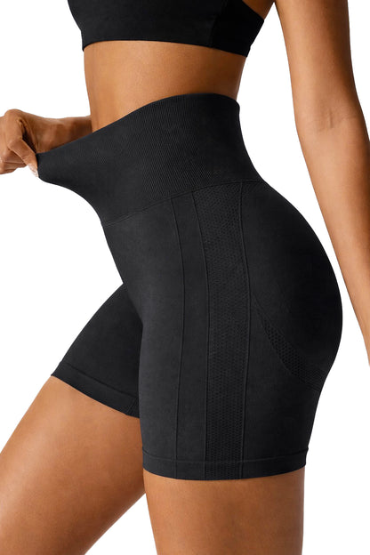 Black athletic shorts worn by a person on a white background