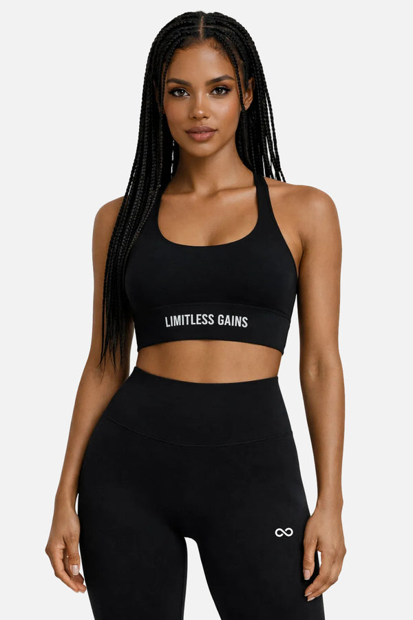 Woman wearing a black sports bra and leggings with 'Limitless Gains' branding on a white background