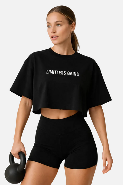 Woman wearing a black 'Limitless Gains' t-shirt holding a kettlebell on a white background