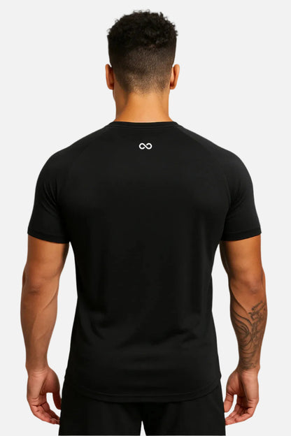 Person wearing a black LIMITLESS GAINS t-shirt with an infinity logo on the back against a white background