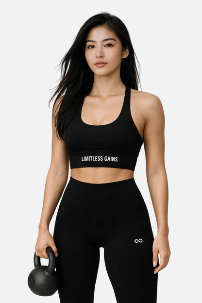 Woman wearing a black sports bra and leggings with 'Limitless Gains' branding, holding a kettlebell.